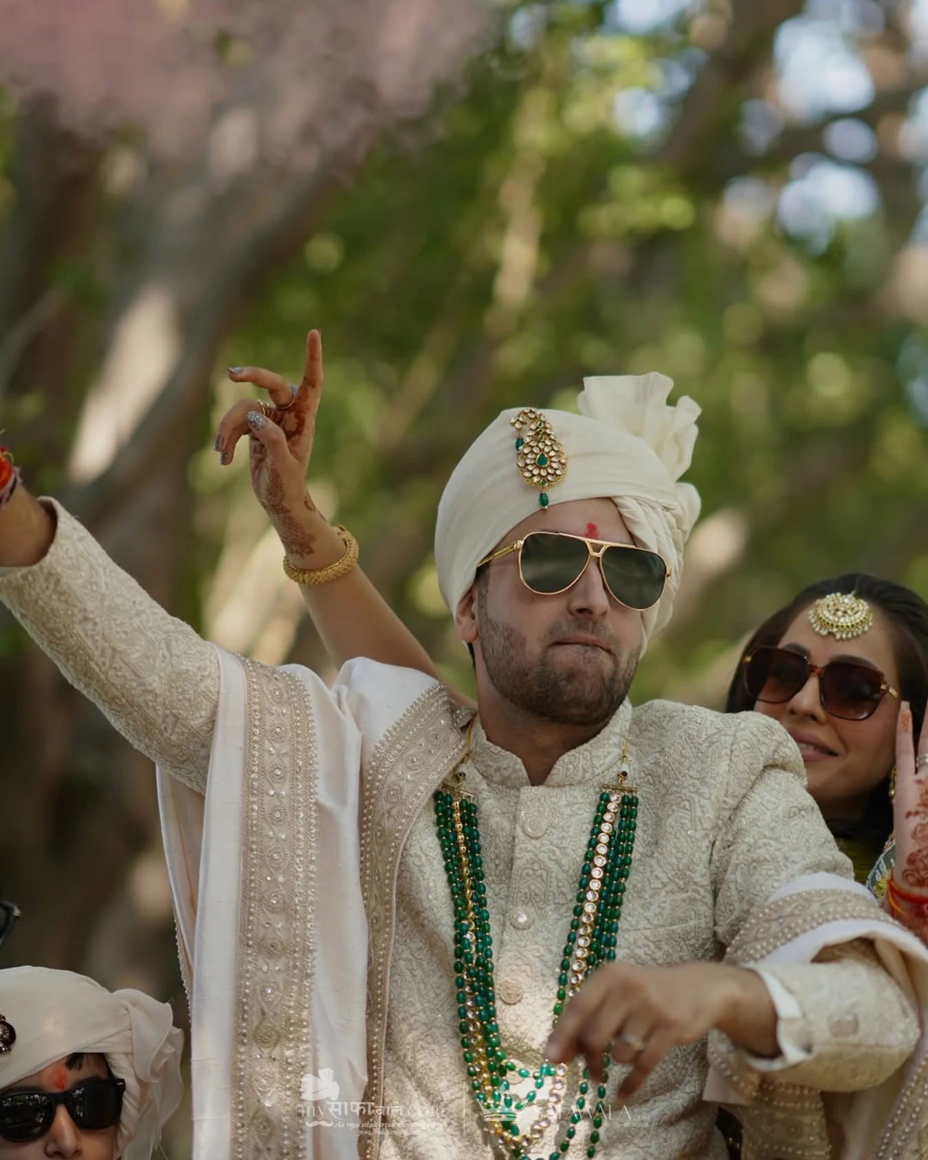 Groom in an ivory wedding safa with emerald jewellery for event pagdi tying in Krabi